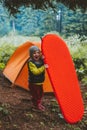 Family camping child with sleeping pad and tent gear travel adventure vacations hiking equipment