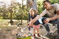 Family camping in forest, cooking meat on barbecue grill. Royalty Free Stock Photo