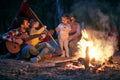 Family camping in the woods; Spring or autumn camping with campfire at night ; camping, travel, tourism, hike and people concept. Royalty Free Stock Photo