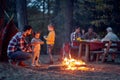 Family camping in the woods; Spring or autumn camping with campfire at night ; camping, travel, tourism, hike and people concept. Royalty Free Stock Photo