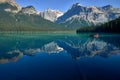 Family canoeing across emerald lake