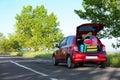 Family car with open trunk full of luggage on highway Royalty Free Stock Photo