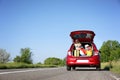 Family car with open trunk full of luggage on highway Royalty Free Stock Photo