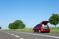 Family car with open trunk full of luggage on highway Royalty Free Stock Photo