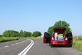 Family car with open trunk full of luggage on highway Royalty Free Stock Photo