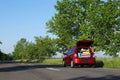 Family car with open trunk full of luggage on highway Royalty Free Stock Photo