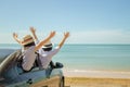 Family car trip at the sea, Woman and child cheerful raising their hands up and feeling happiness.