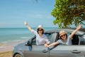 Family car trip at the sea, Woman and child cheerful raising their hands up and feeling happiness.