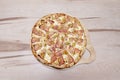 Family carbonara recipe pizza with a lot of mozzarella cheese and york ham on an unvarnished wooden table Royalty Free Stock Photo