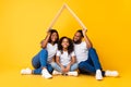 Happy African American parents holding cardboard roof above daughter Royalty Free Stock Photo