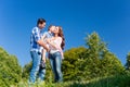 Family carrying kid, the parents standing on meadow