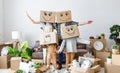 Family in carton boxes on heads in new apartment