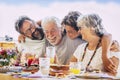 Family caucasian people hug and enjoy celebration together - mixed ages with teeanger, adult and senior people having lunch and
