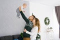 Family celebrates Christmas at home in the living room near the Christmas tree. Happy mom, dad and son enjoy their vacation togeth Royalty Free Stock Photo