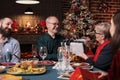 Family celebrating christmas, exchanging gifts at festive served table