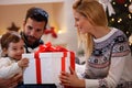 Family celebrating Christmas at home. father and mother give a c Royalty Free Stock Photo