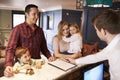 Family Checking In At Hotel Reception Desk