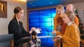 A family checking in the hotel room - a woman on the reception explaining them everything about the hotel Royalty Free Stock Photo