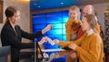 A family checking in the luxury hotel - a woman on the reception gives a brochure and keys to them Royalty Free Stock Photo