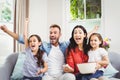 Family cheering while watching TV at home