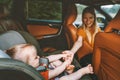 Family child in car holding mother hand baby sitting in safety seat mom driver Royalty Free Stock Photo