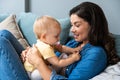 Family, child and motherhood concept - happy smiling young mother hugging little baby at home. Woman and her newborn boy or girl Royalty Free Stock Photo