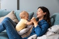 Family, child and motherhood concept - happy smiling young mother hugging little baby at home. Woman and her newborn boy or girl Royalty Free Stock Photo