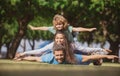 Family and child outdoors in spring nature. Fly concept, little boy is sitting pickaback while imitating the flight