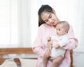 Family, child and parenthood concept - happy beautiful young asian mother smiling hugging holding newborn baby in her arms at home Royalty Free Stock Photo