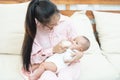 Family, child and parenthood concept - happy beautiful young asian mother smiling hugging holding newborn baby in her arms at home Royalty Free Stock Photo