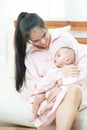 Family, child and parenthood concept - happy beautiful young asian mother smiling hugging holding newborn baby in her arms at home Royalty Free Stock Photo