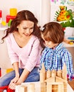 Family with child playing bricks.