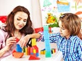 Family with child playing bricks.