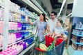 Family with child and shopping cart buying food at grocery store or supermarket Royalty Free Stock Photo