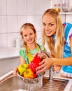 Family with child washing fruit at kitchen