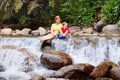 Family with child at waterfall. Travel with kids