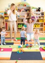 Family, childhood, activity and creativity concept - happy parents and their little kids having a fun in playroom