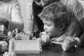 Family and childhood concept. Baby boy looks at train made out of construction blocks. Royalty Free Stock Photo