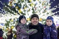 Family, childhood, season and people concept - happy in winter clothes over snowy city background Royalty Free Stock Photo