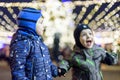 Family, childhood, season and people concept - happy in winter clothes over snowy city background Royalty Free Stock Photo