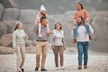 Family, children and beach with grandparents, parents and grandkids walking on the sand at the coast together. Summer