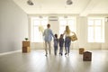 Family with children on day of moving walks in future living room in their new home. Royalty Free Stock Photo