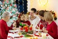 Family with kids having Christmas dinner at tree Royalty Free Stock Photo