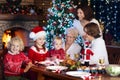 Christmas dinner. Family with kids at Xmas tree. Royalty Free Stock Photo