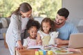 Family, children and education with a mother and father teaching their girl kids in the living room while doing homework Royalty Free Stock Photo