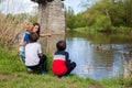 Family with children, feeding ducks in a river in front of old wooden cottage on brick pillar in The Radbuza River, near Chotesov Royalty Free Stock Photo