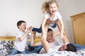 Family, children and home concept - happy family with two kids under blanket at home