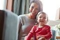 Family, children or love with a mother and girl together in the living room of their home, sitting on a sofa. Mama, baby