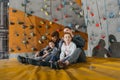 Family with children sitting on a mat at gym with climbing walls Royalty Free Stock Photo