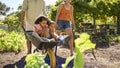 Family With Children Pushed In Barrow By Parents Working In Vegetable Garden Or Allotment Royalty Free Stock Photo